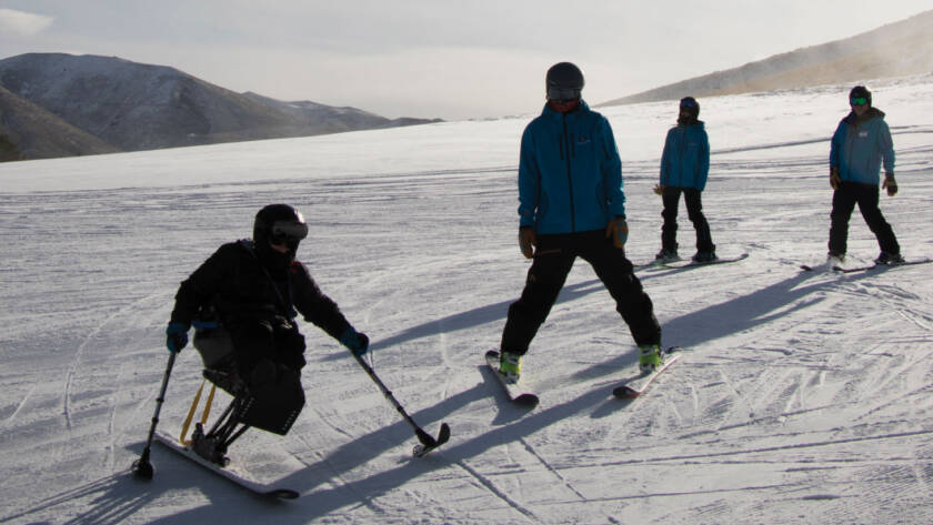 Skiers and snowboarders on sunny slope