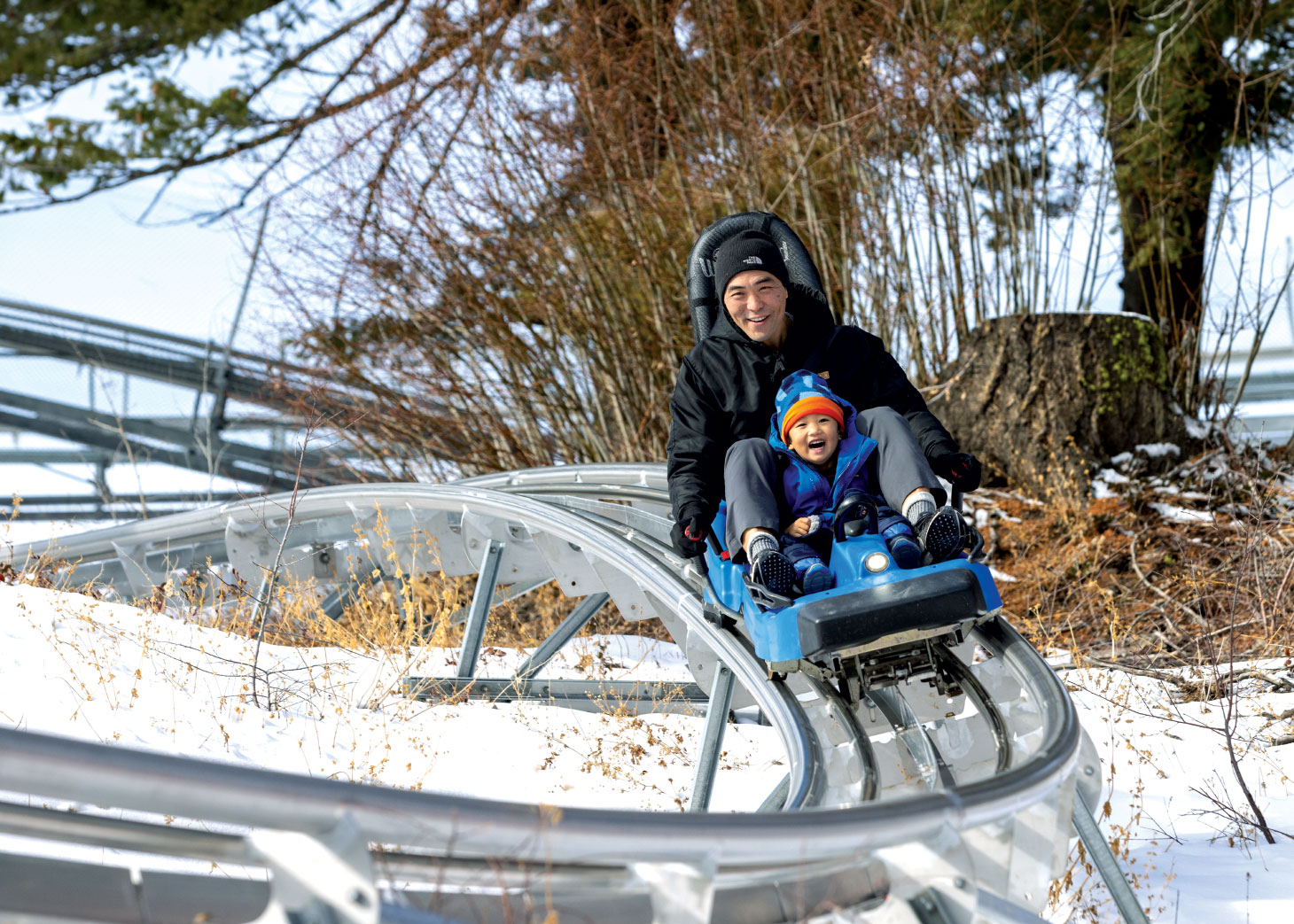 Man riding roller coaster style ride with son