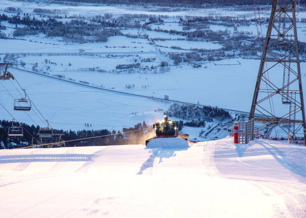 Winch Cat grooming machine coming over mountaintop