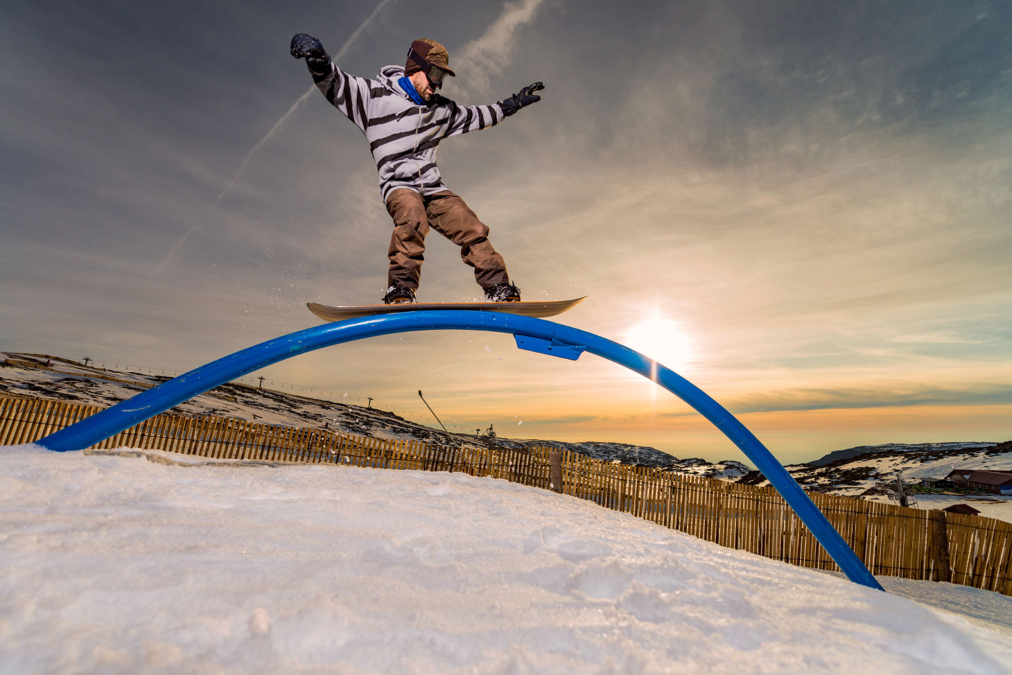 Snowboarder riding rail obstacle