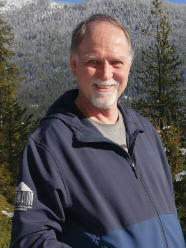 Bob Dodge smiling, with mountains in background