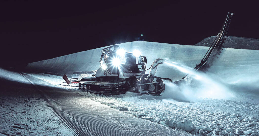 Snow grooming machine working at night