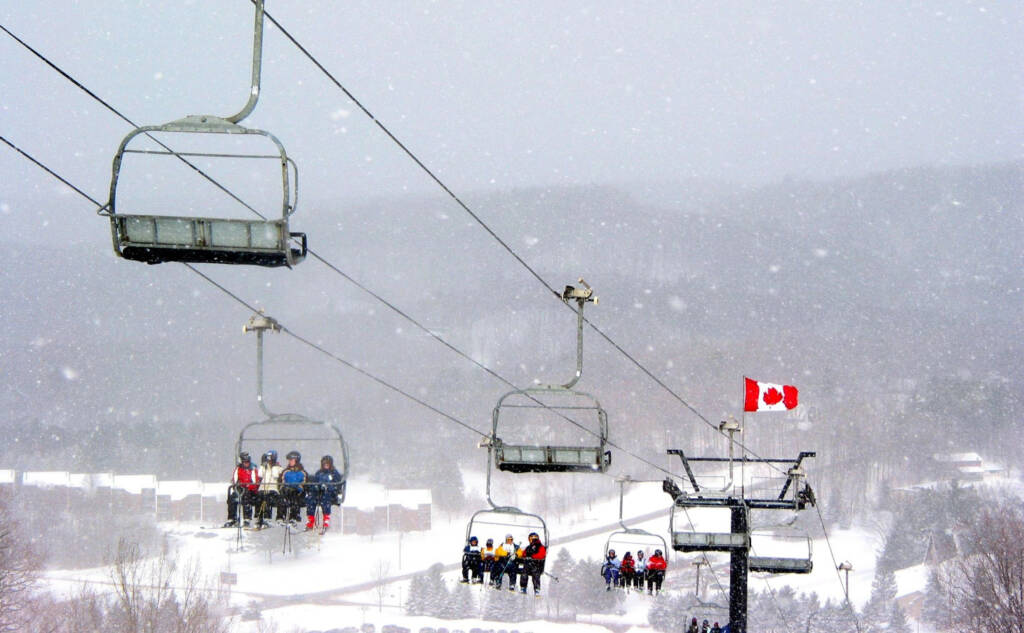 Chair lift carrying passengers in snowfall