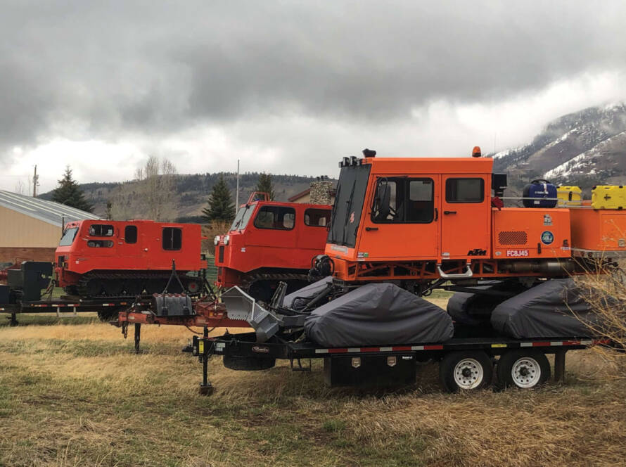 Snowcats sitting storage on trailers