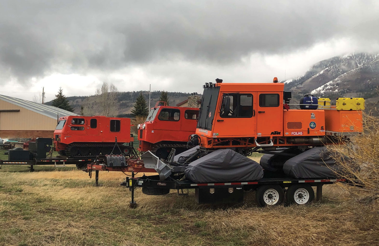 Snowcats sitting storage on trailers