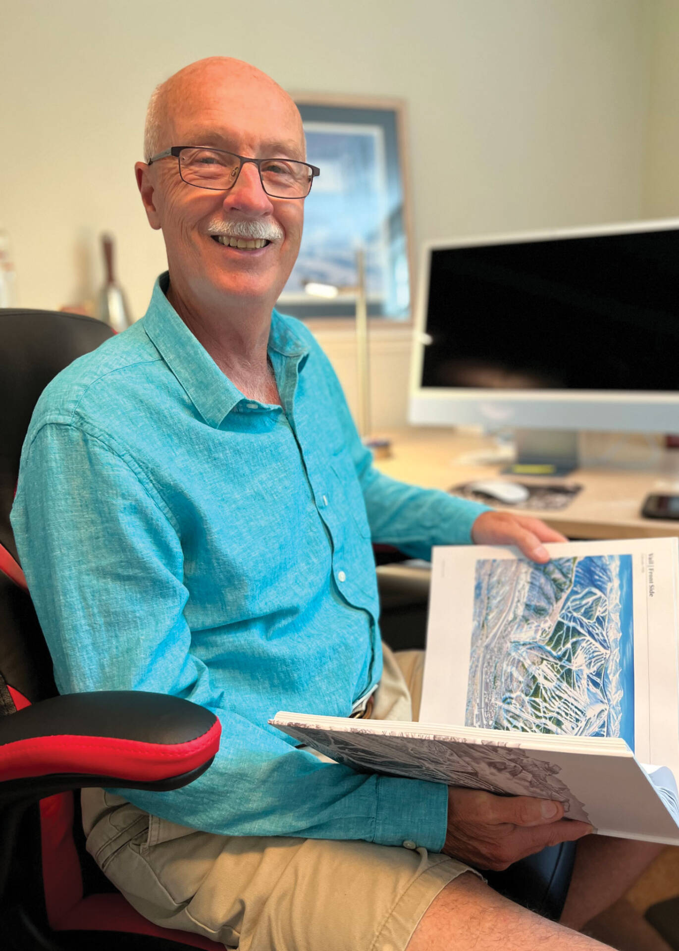 Jacques Pelletier sitting in chair with open book on lap