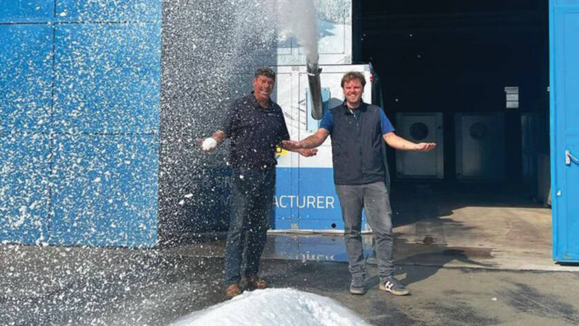 Albert Bronander and Roberto Penocchio standing in front of snow blowing machine