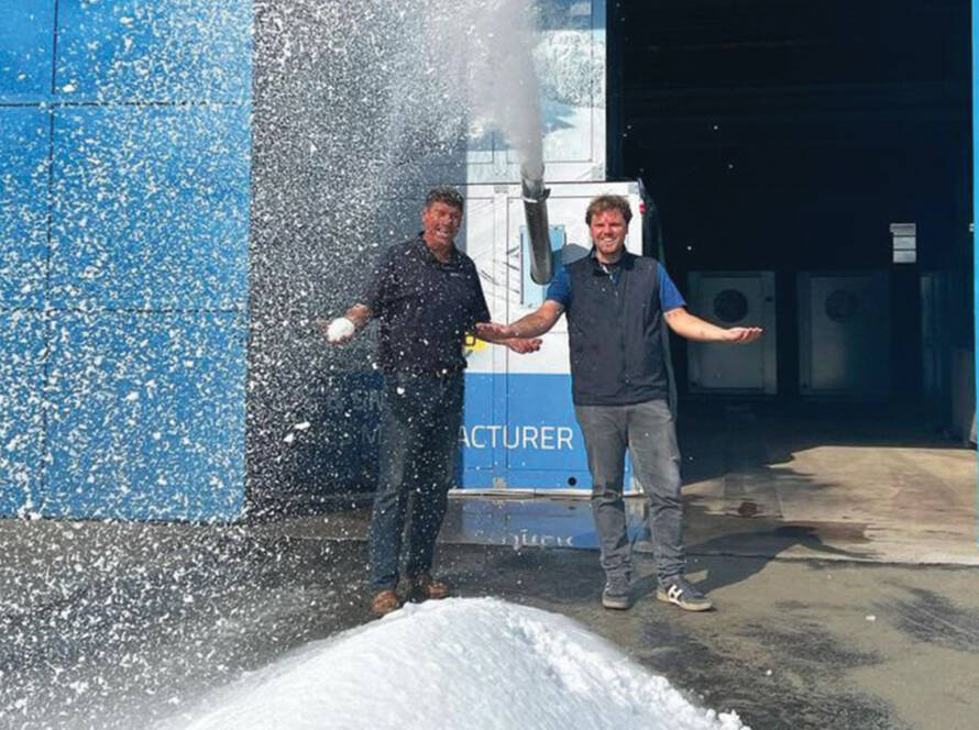 Albert Bronander and Roberto Penocchio standing in front of snow blowing machine