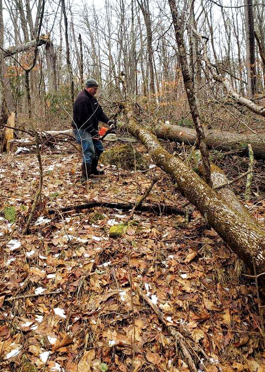 Doug Haddad clearing fallen tree from trail