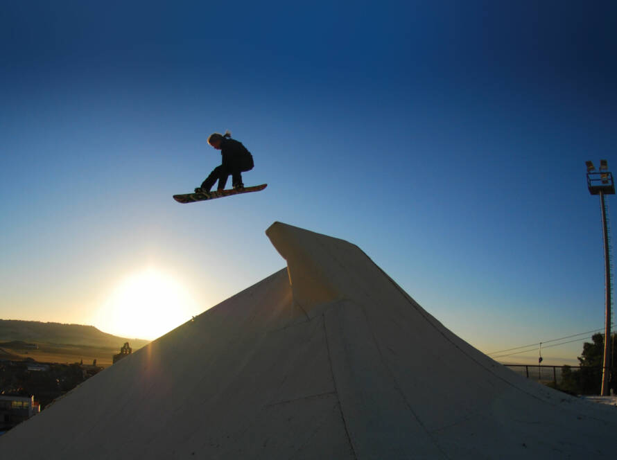 Snowboarder jumping off ramp