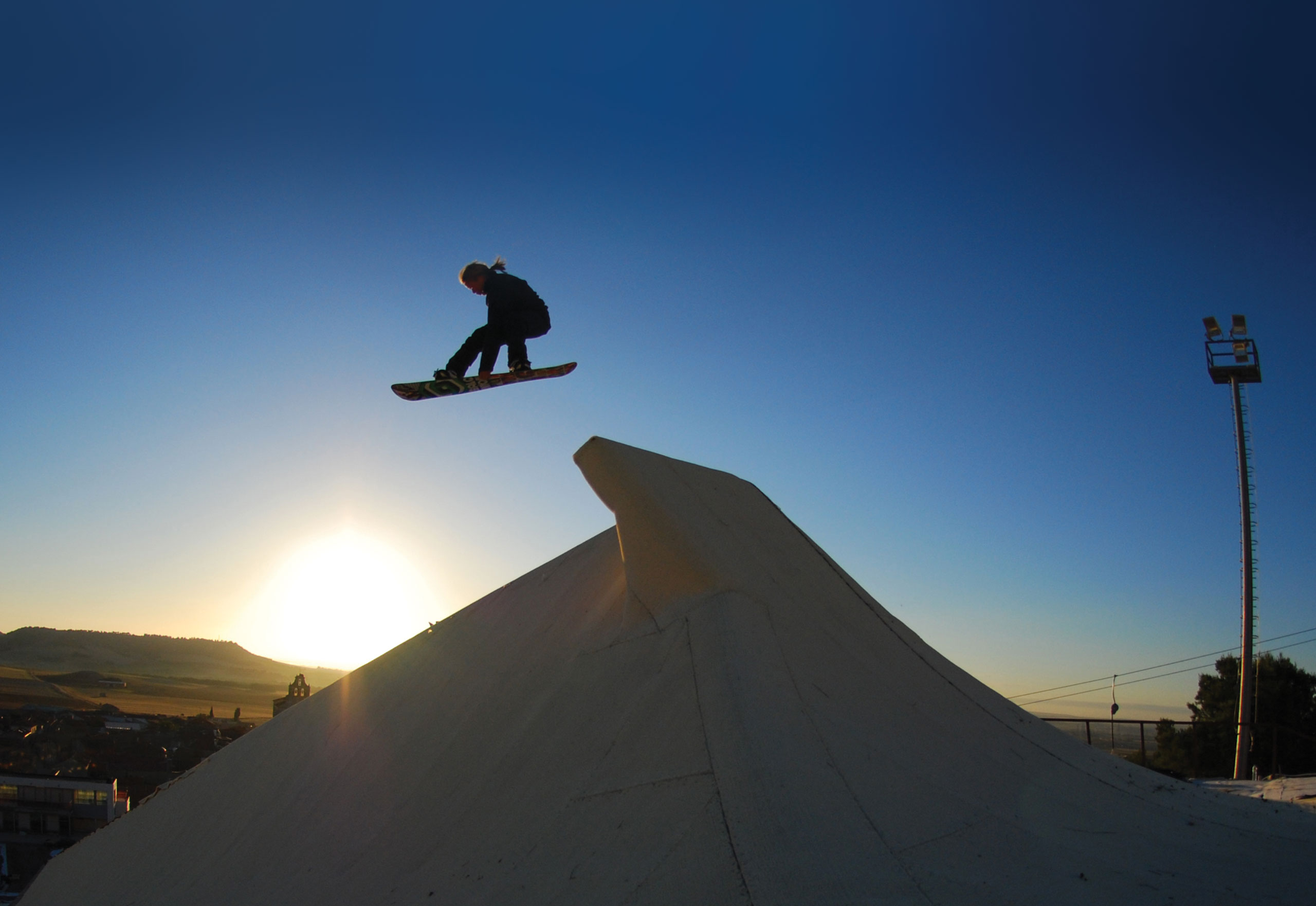 Snowboarder jumping off ramp