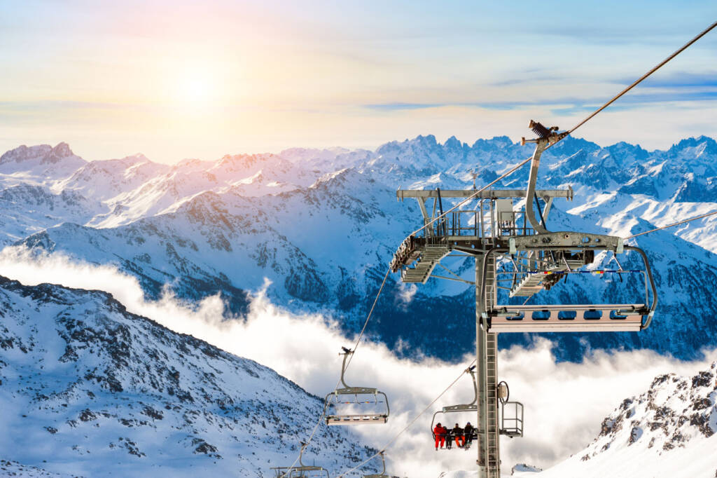 Skiers on chairlift with gorgeous mountain landscape