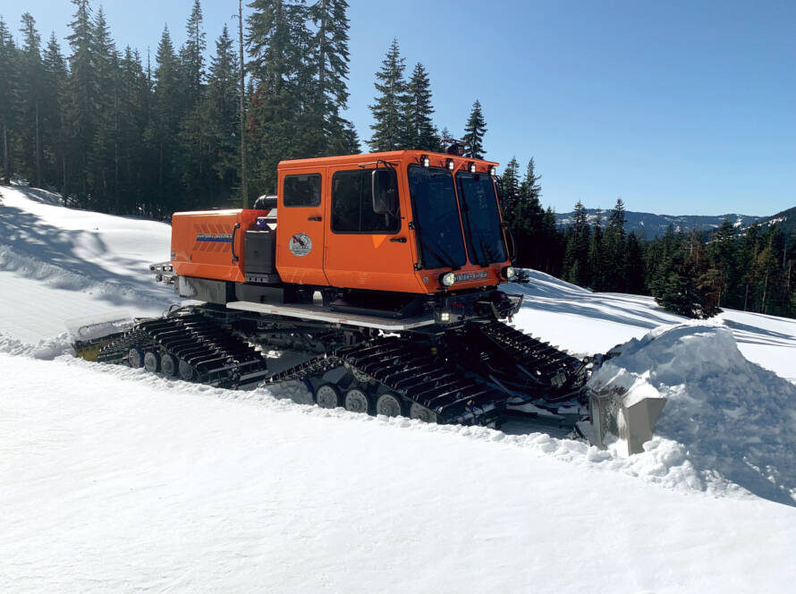 Snow grooming machine pushing snow