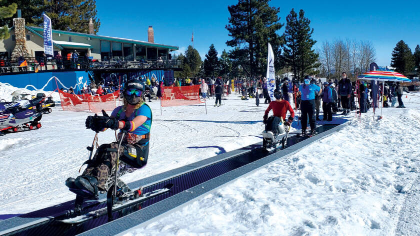 Skiers with disabilities on carpet lift