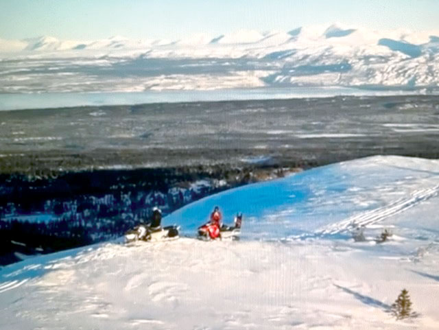 Snowmobilers on mountaintop