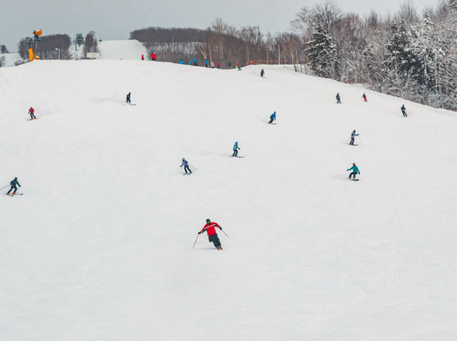 skiers and snowboarders coming down mountain