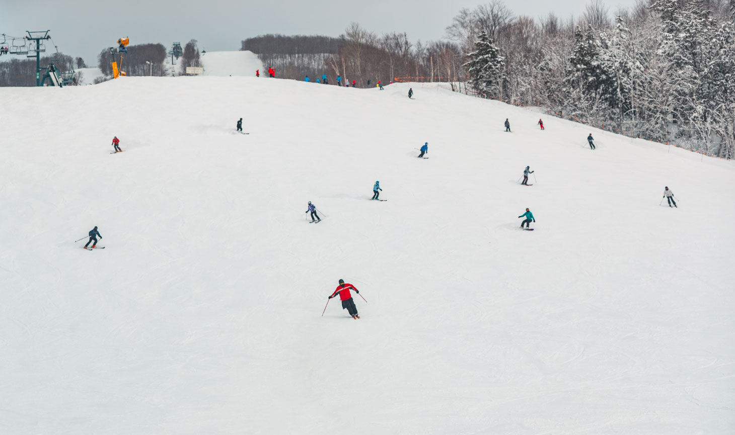 skiers and snowboarders coming down mountain