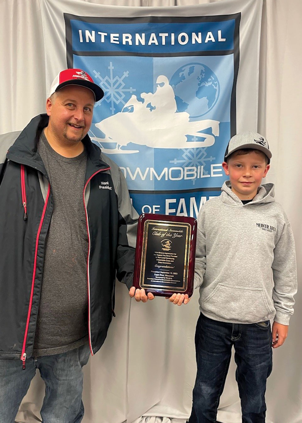 Levi standing in front of banner accepting award