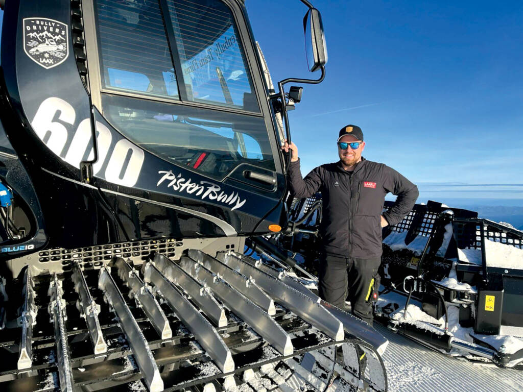 Matthias Sommer posing against Pisten Bully snowgrooming machine