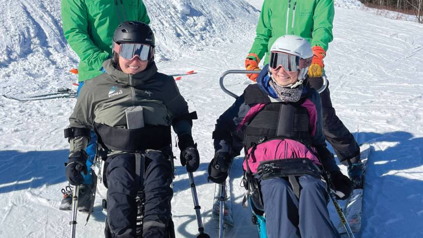 Four skiers in snow gear and specialized ski equipment