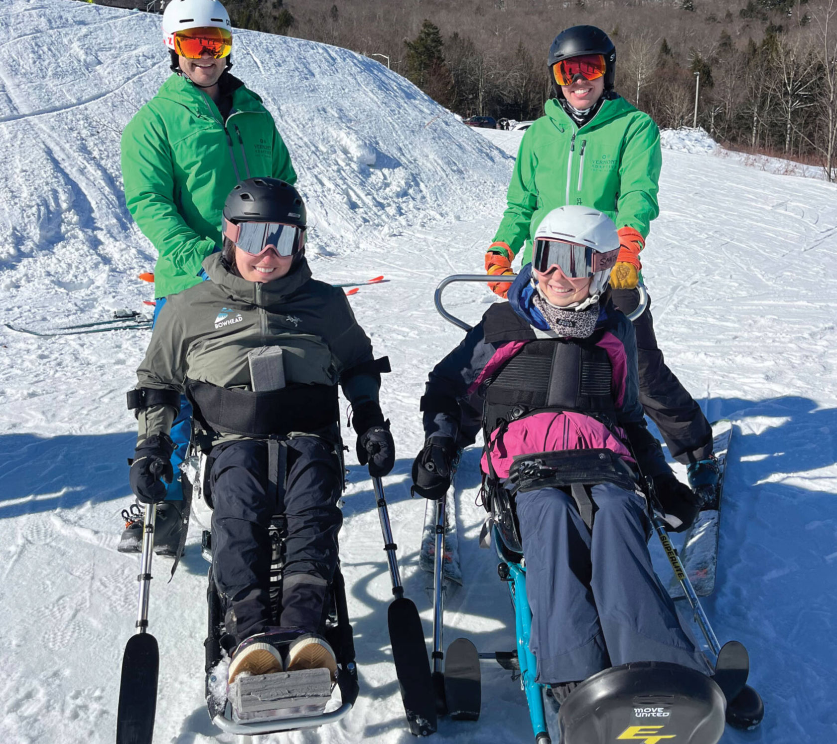 Four skiers in snow gear and specialized ski equipment