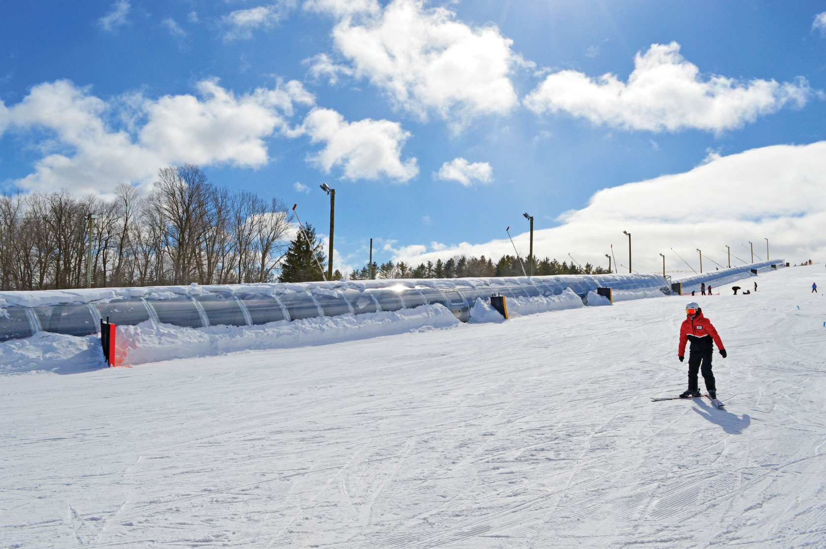 Skier on slope with Team Service moving carpet in background