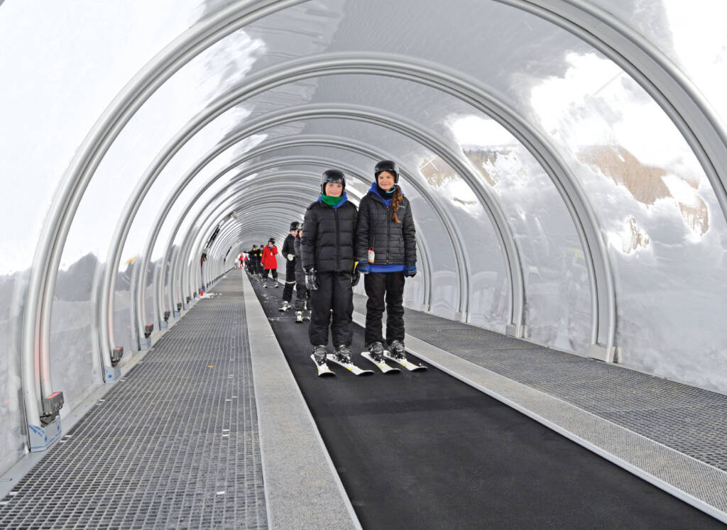 Young skiers riding a TS-Premium carpet lift