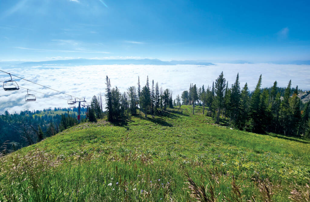 Landscape photo with ski lifts and bright sunny sky in background