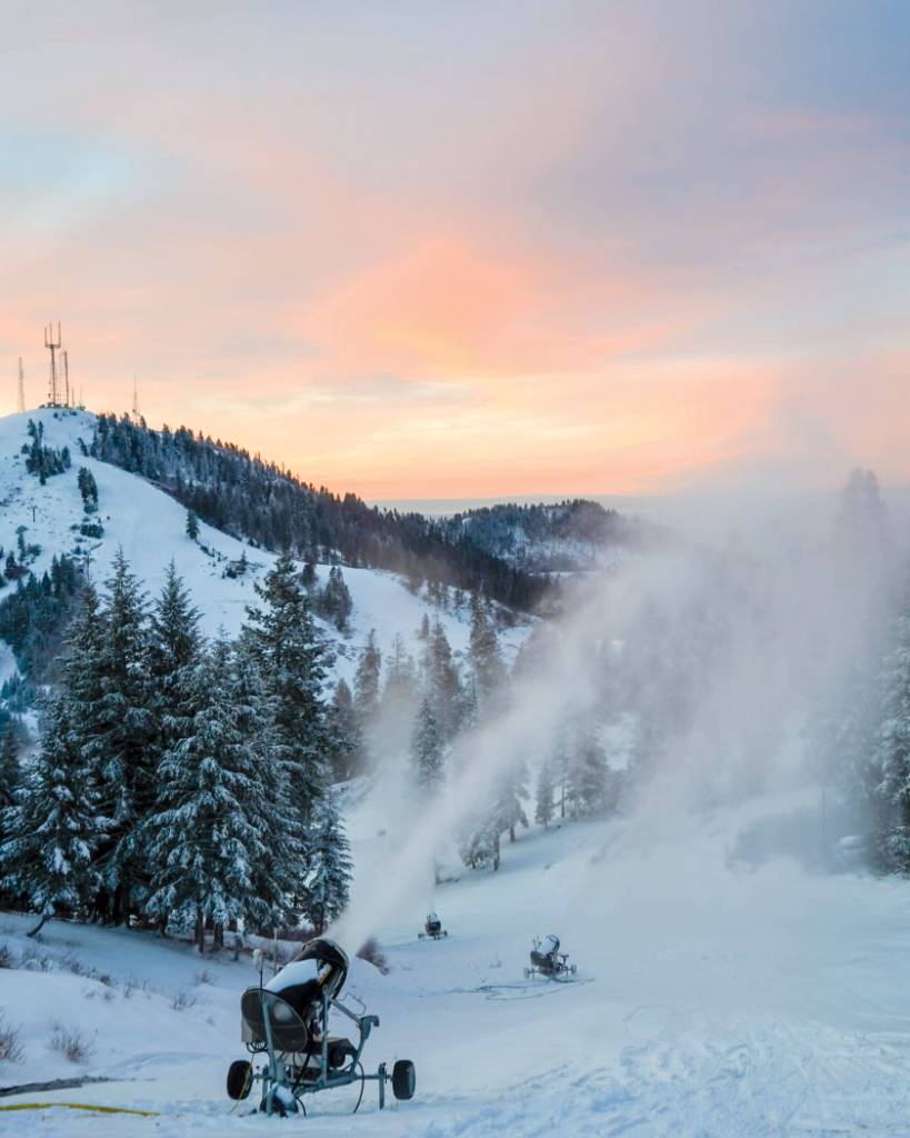 Snow shooting high into the air from snowmaking machine