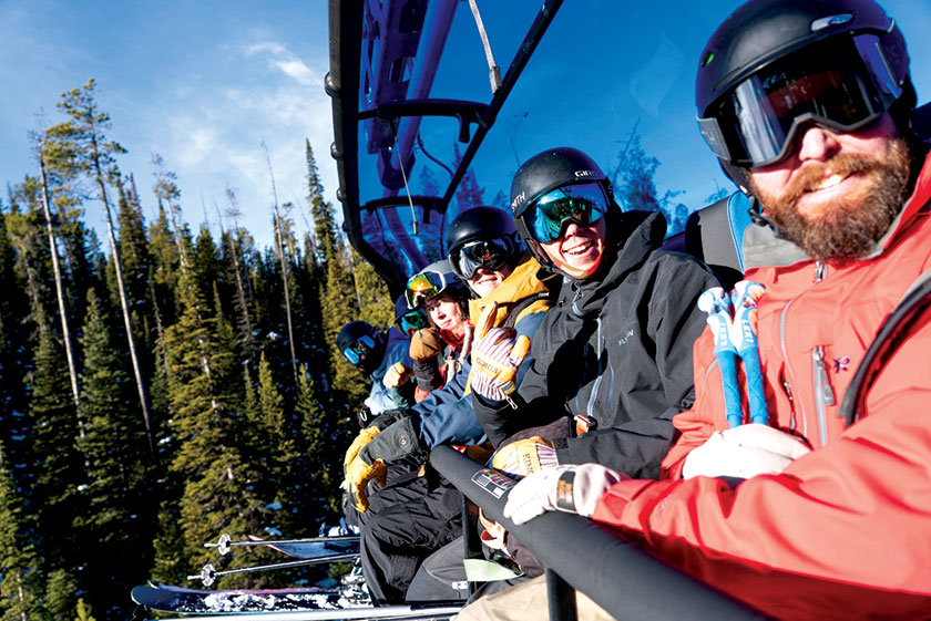 Happy skier and snowboarders enjoying the new ski lift