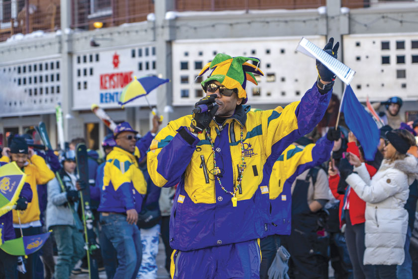 Group in matching yellow and purple team jackets parade in streets