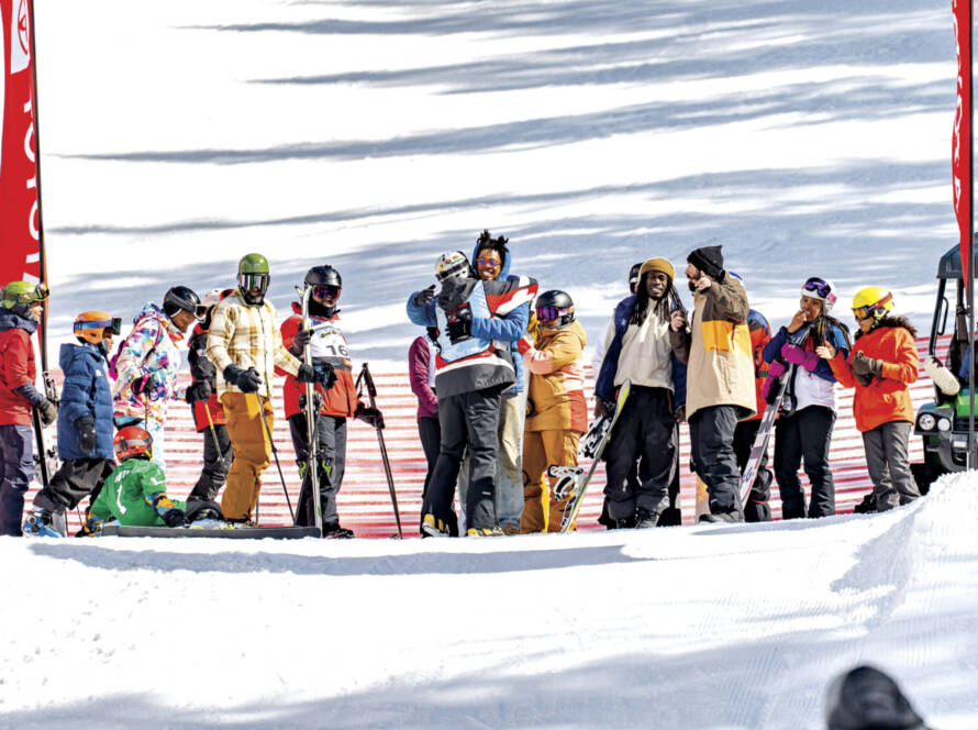 Group gathered on mountain with two in foreground hugging