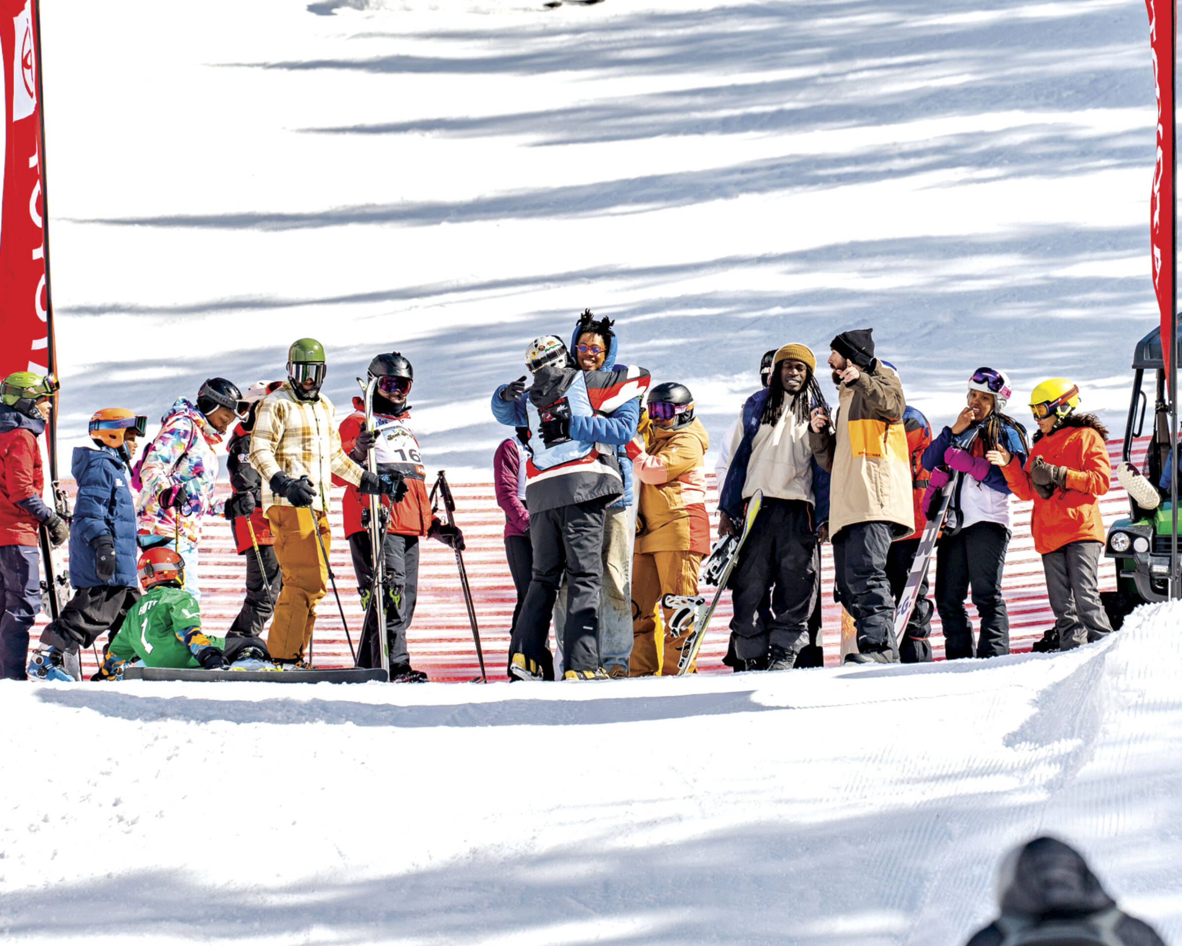 Group gathered on mountain with two in foreground hugging