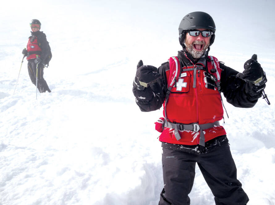 Ski patroller giving enthusiastic thumbs up