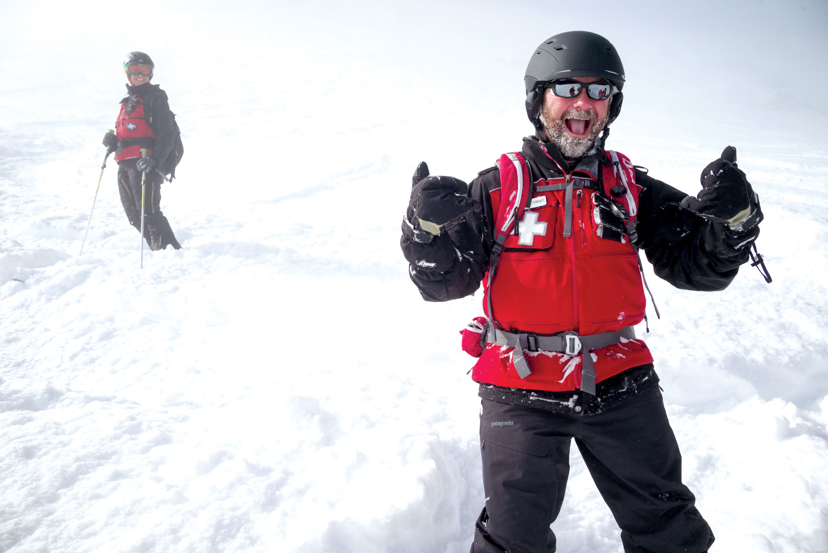 Ski patroller giving enthusiastic thumbs up
