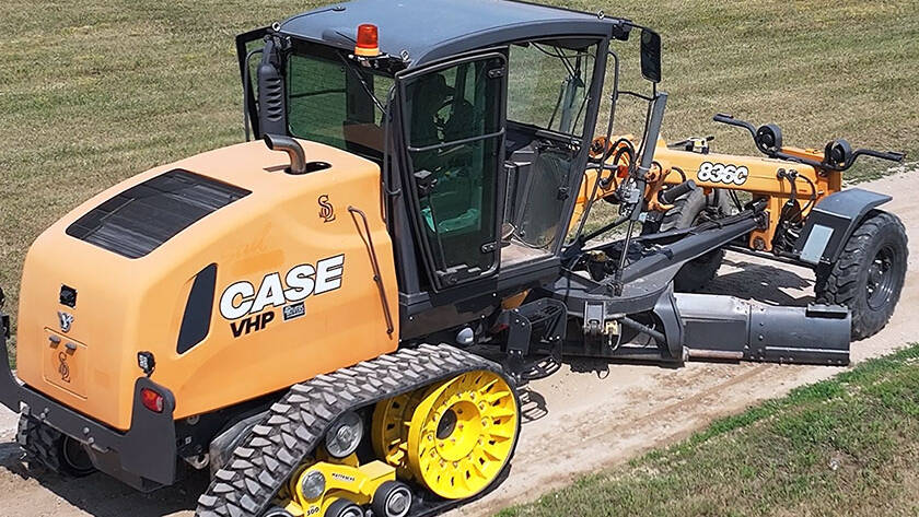 Grader fitted with Mattracks TD300 working on rural road