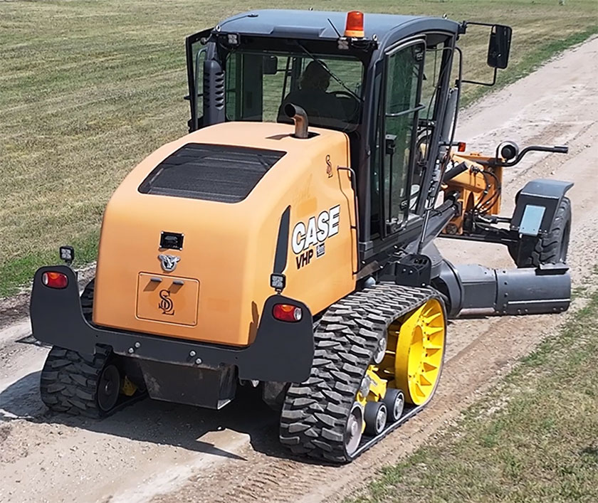 Grader fitted with Mattracks TD300 working on rural road
