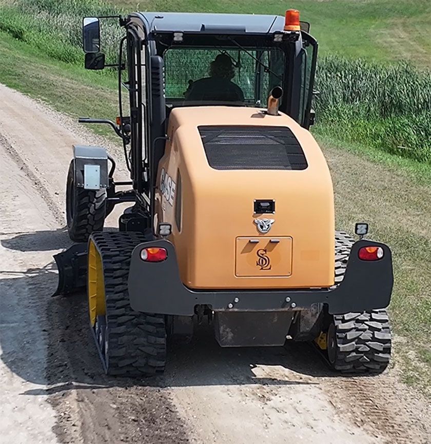 Grader fitted with Mattracks TD300 working on rural road