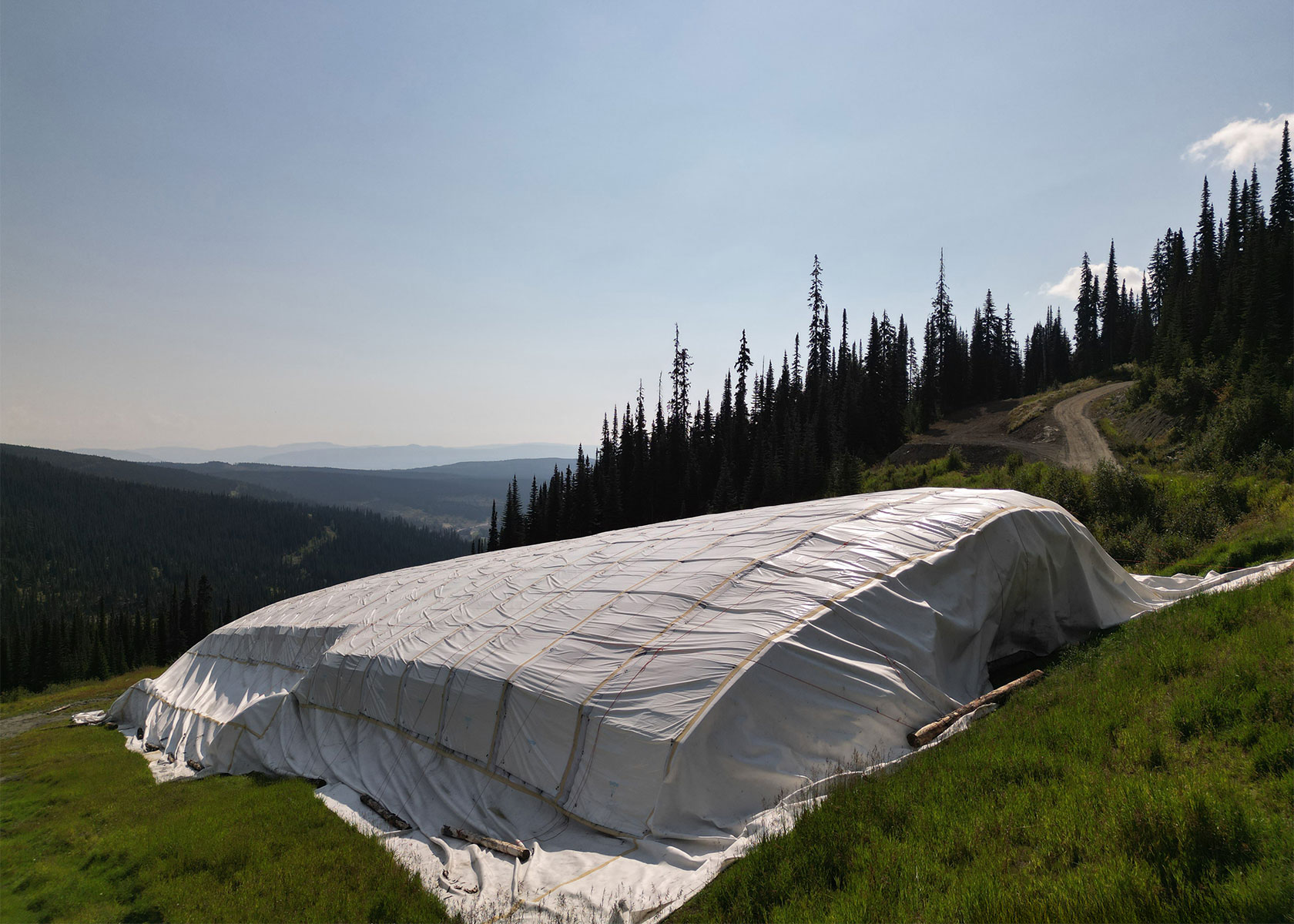 Snow Secure’s storage system securing snow in summer, surrounded by green grass
