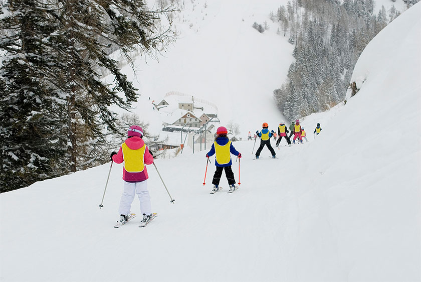 Children skiing after a snowfall. Vigezzo Valley, Italy